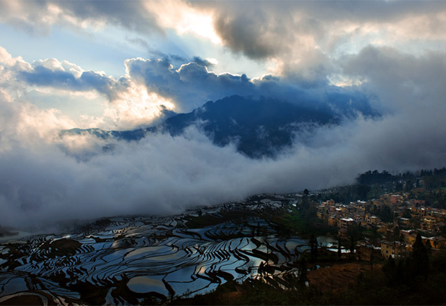 雲間から朝日が棚田を照らす絶景