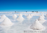 乾季のウユニ塩湖には天日干しにされる潮の小山が並ぶ